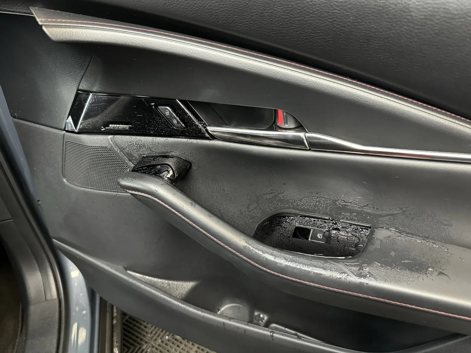 Panel de puerta de un Mazda durante la limpieza de plásticos y viniles