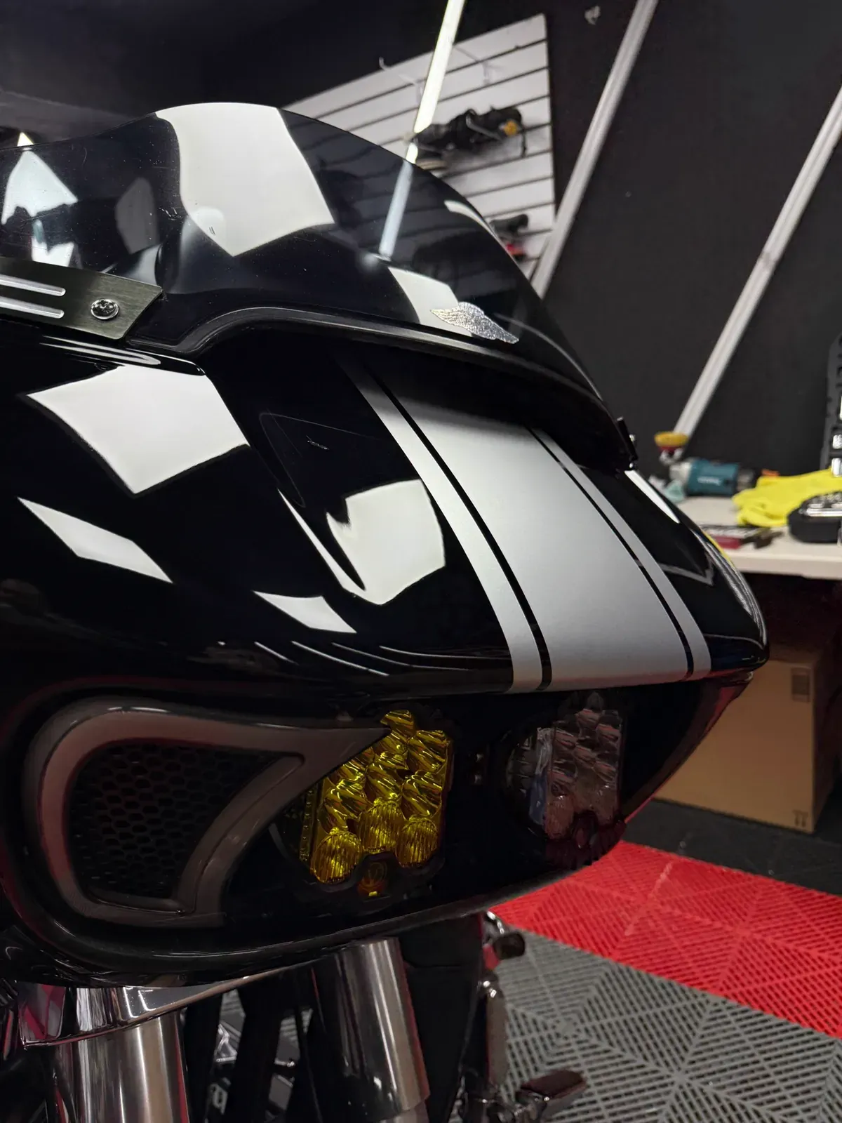 Carenado negro de motocicleta con acabado brillante bajo luz de inspección
